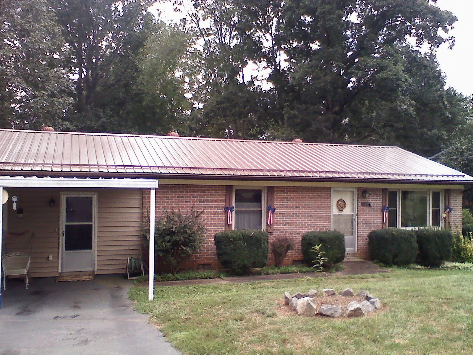 Bronze metal roof and carport on a brick ranch home — Roof Repair work by our crew in Alexandria
